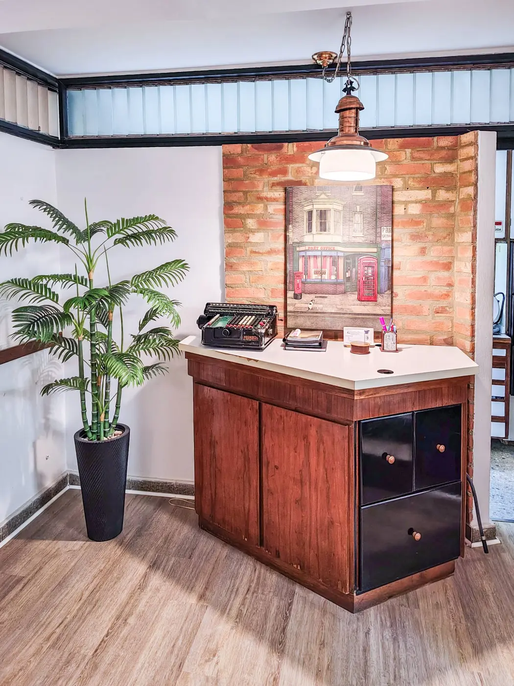 Recepción con pared de ladrillo y planta